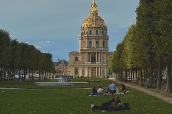 students sitting in the grass at the Park and Hotel des Invalides in Paris