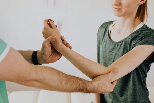 A physical therapist assisting a patients in her range of motion.