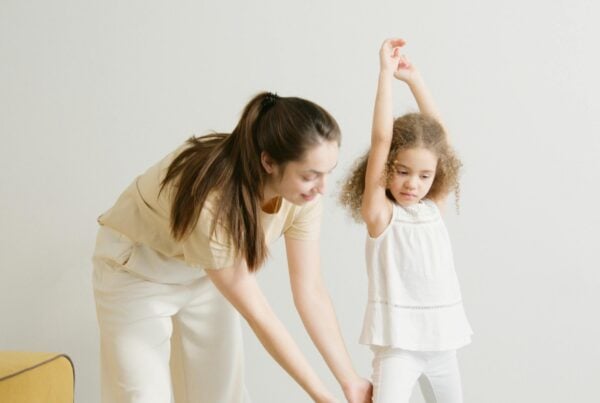 An intern helping out a kid stretch in Ireland during her occupational therapy session.