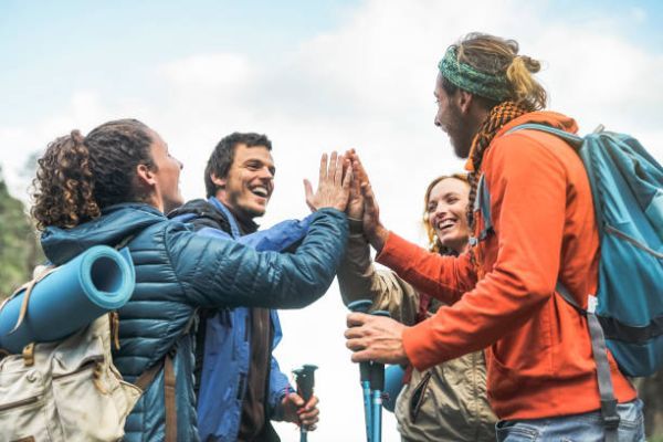 in-text image 12 Group of friends stacking hands on peak of mountain.