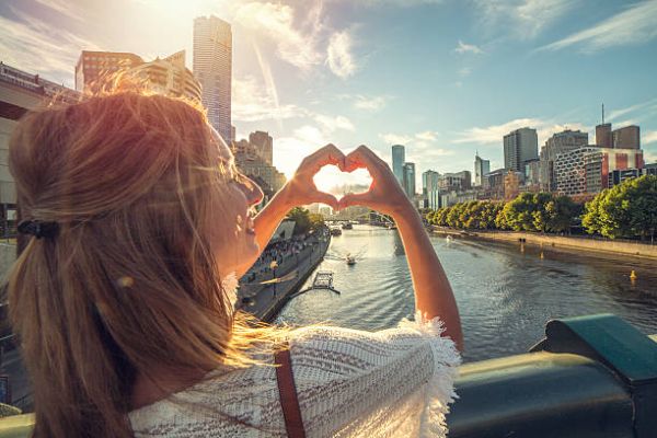 in-text image 8 Cheerful young woman in Melbourne makes a heart shape finger frame.
