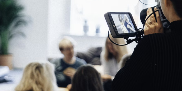 A woman using a video camera to record a conversation.